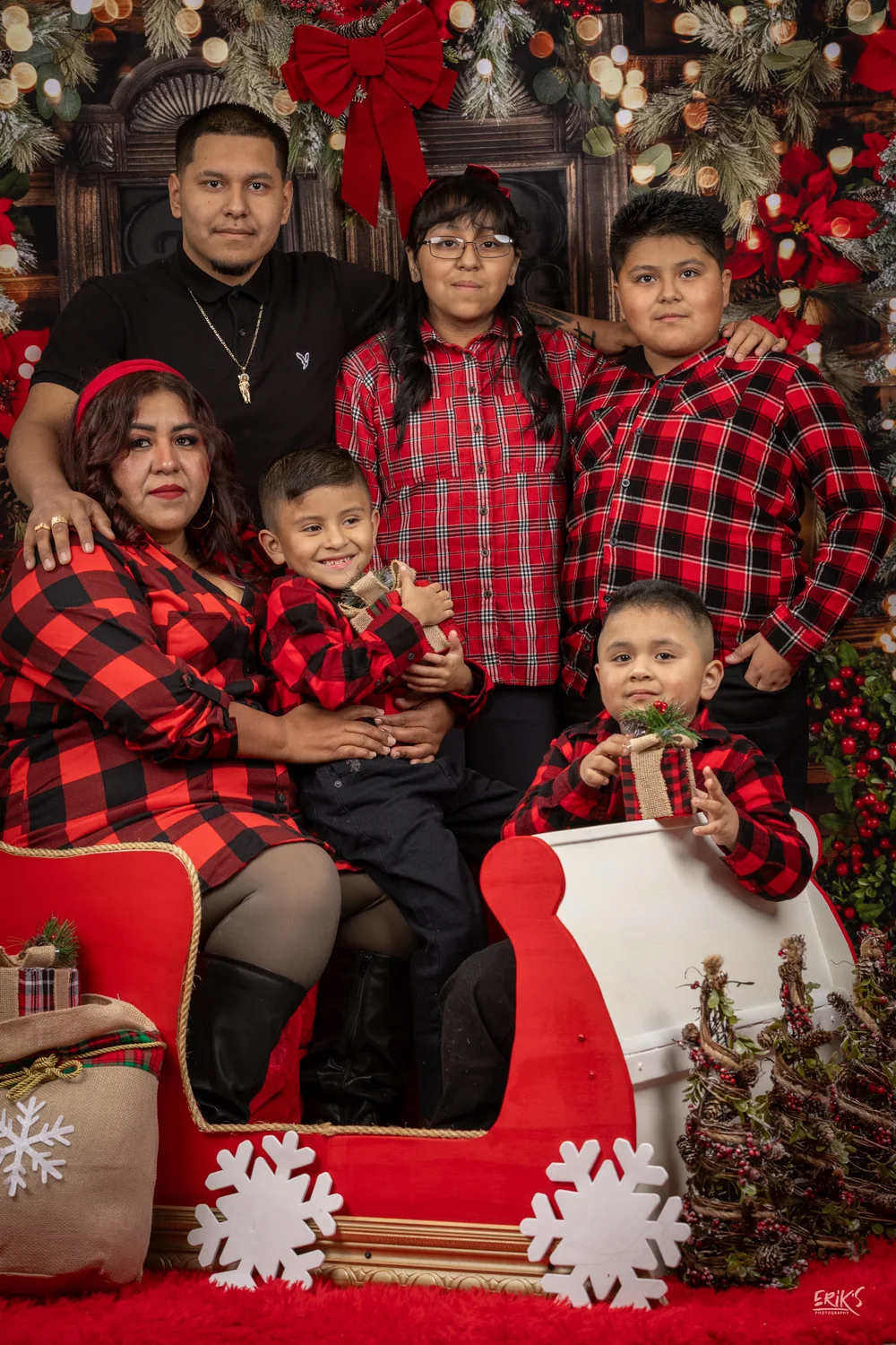 Familia con pijamas de cuadros junto al trineo
