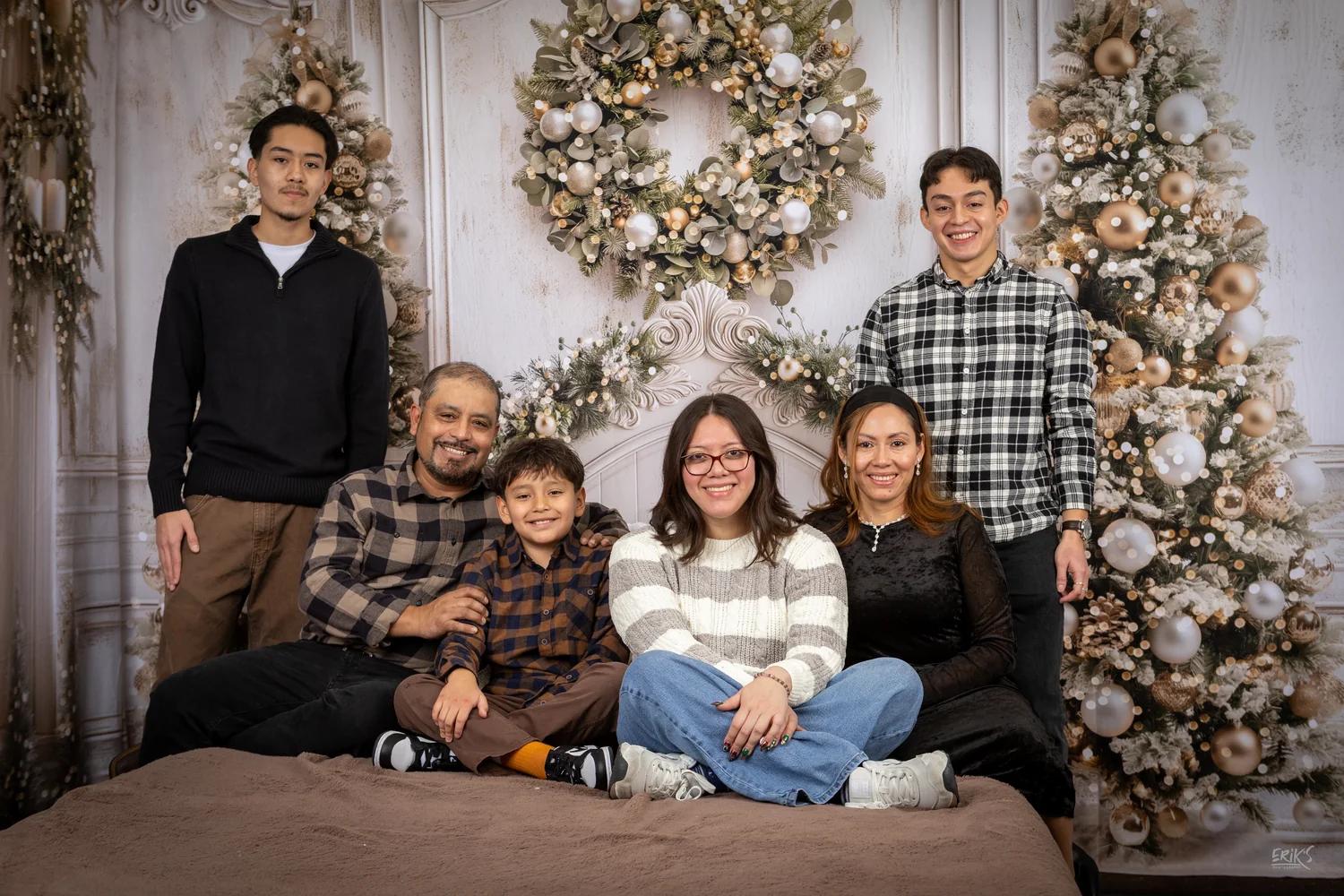 Familia reunida frente a un árbol blanco y dorado